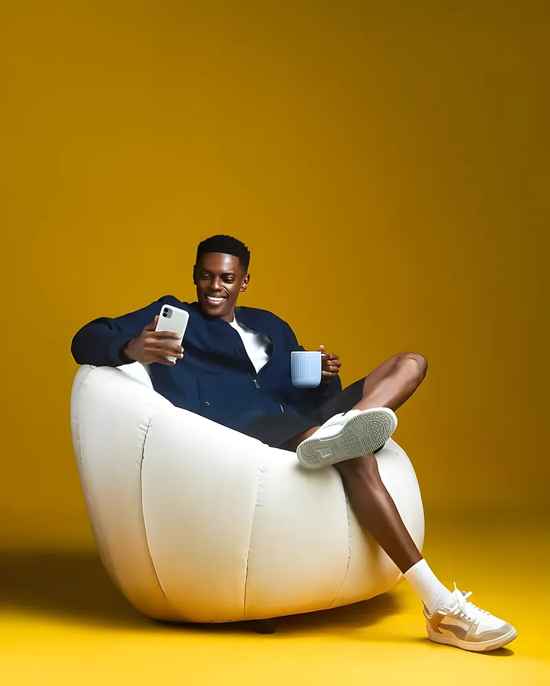 Man relaxing in a bean-bag chair with his phone