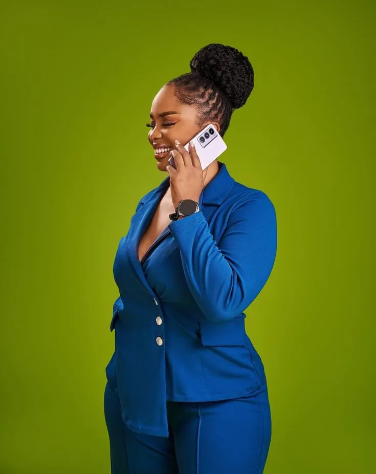 Smiling woman in a blue suit talking on her phone